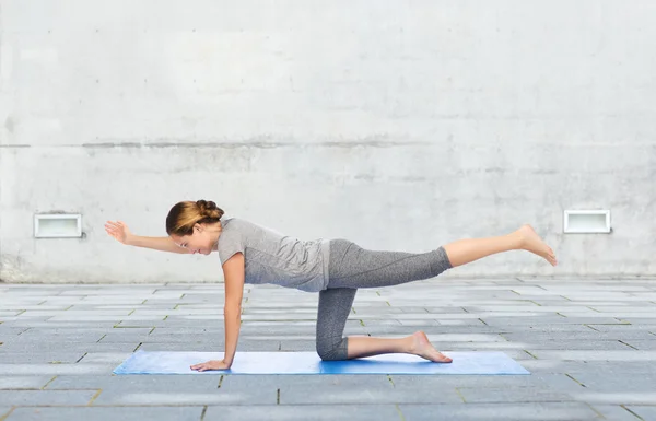 Woman making yoga in balancing table pose on mat