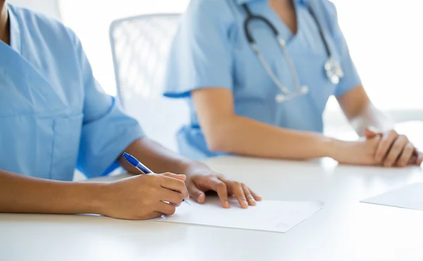 Close up of doctor taking notes at hospital