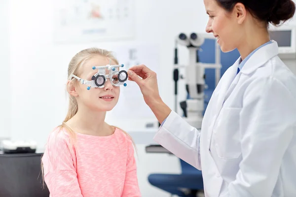 Optician with trial frame and girl at clinic