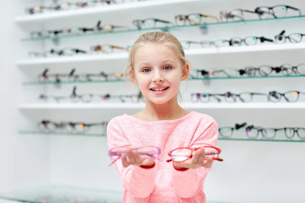 Little girl in glasses at optics store