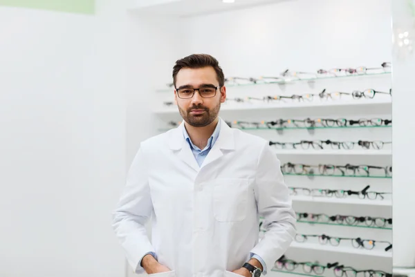 Man optician in glasses and coat at optics store