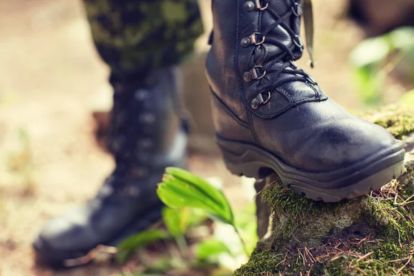 Close up of soldier feet with army boots in forest