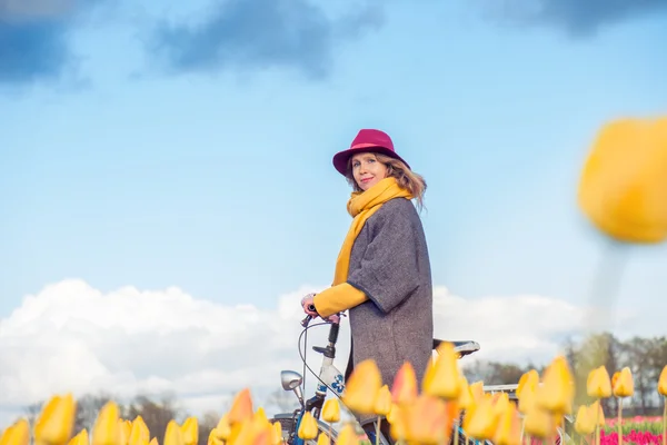 Female riding her bike through tulip fields