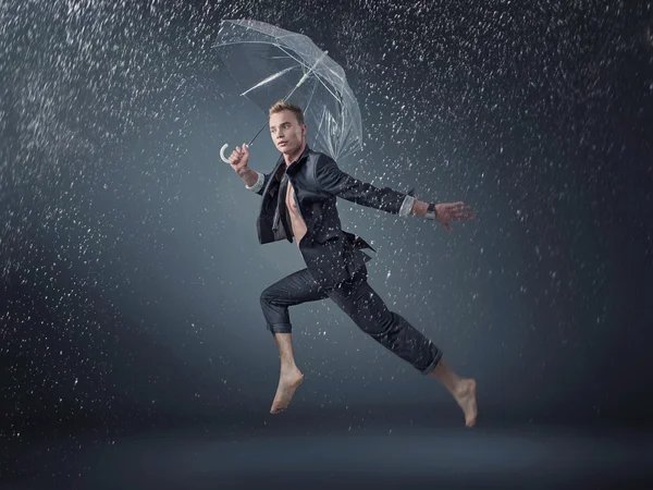Handsome man jumping and dancing in the rain