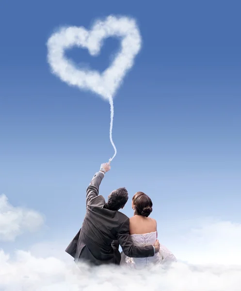 Just married couple sitting on the cloud