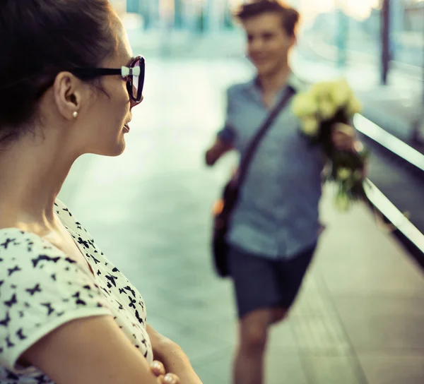 Happy guy trying to give a bouquet of roses to some lady