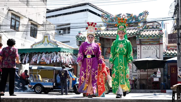 Chinese opera actors walking across the street to offering Shrine of the Black Sea