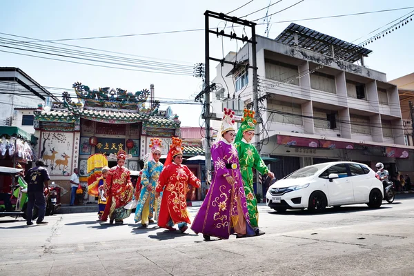 Chinese opera actors walking across the street to offering Shrine of the Black Sea