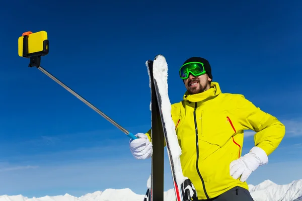 Skier man taking selfie with stick
