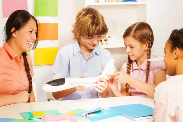 Boy in glasses demonstrating aircraft model