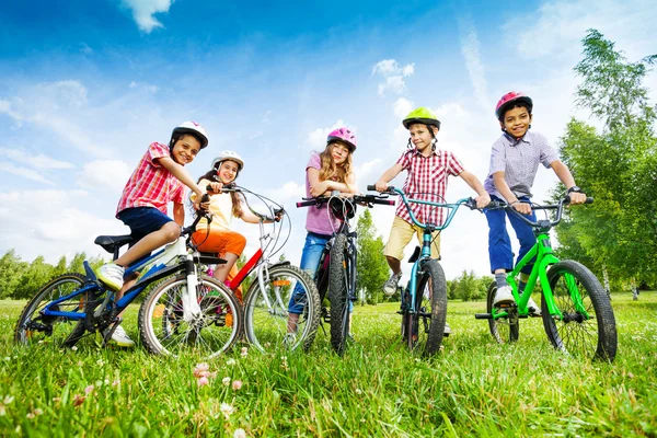 Children hold their bikes