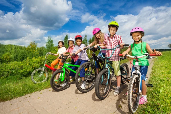 Children in row holding bikes