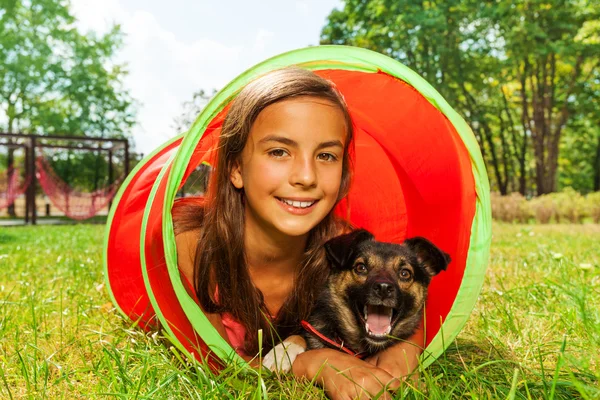 Girl with dog in playground tube