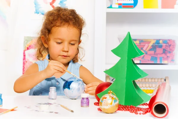 Girl paints New Year ball