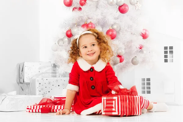 Girl with presents under Christmas tree