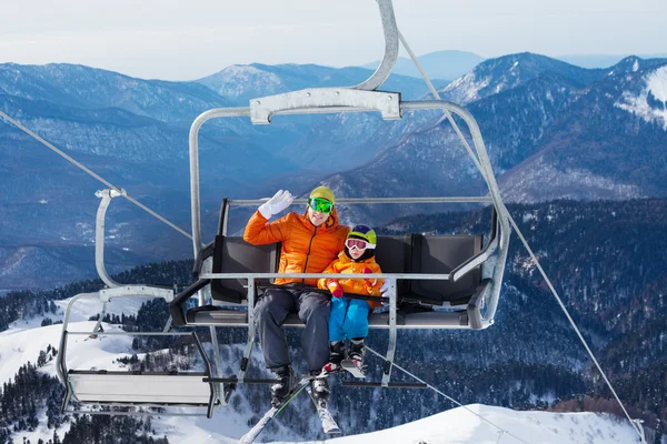Man with child lift on ropeway chair