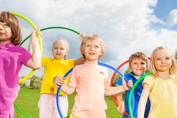 Children holding hula hoops in park