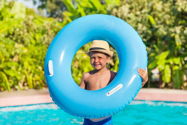 Boy  holds inflatable ring near pool