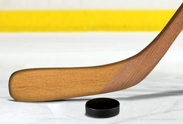 Ice hockey stick and puck on rink