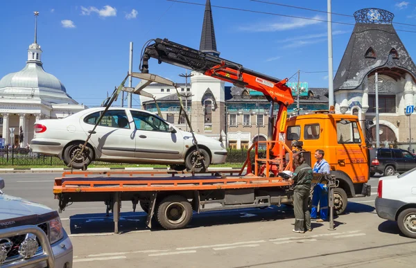 Loading of automobile car on wrecker for parking infringement in