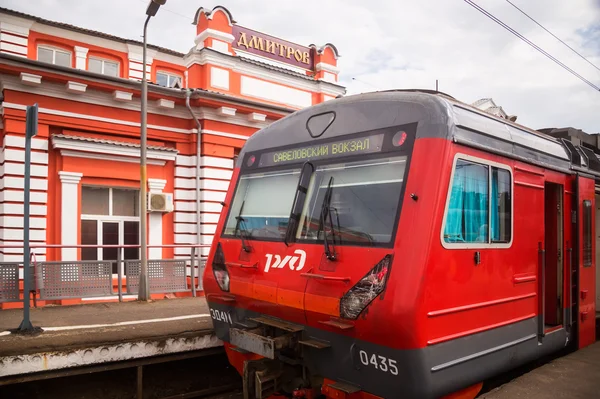 Electric train stands at platform against station in the city of