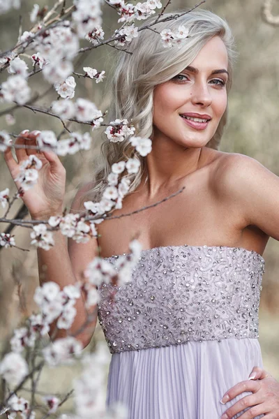 Blonde woman in a flowered garden