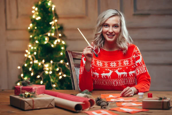 Woman painting christmas flags with brush