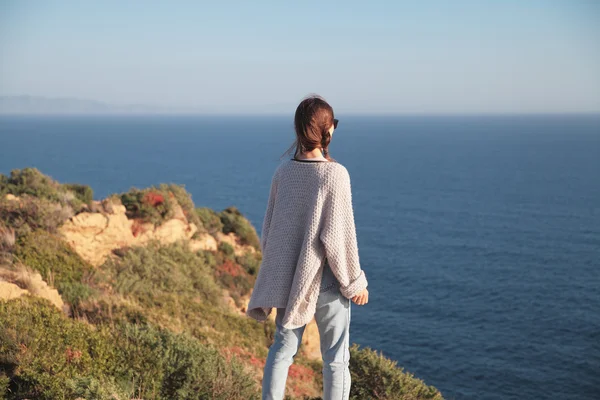 Traveler young woman stands on a cliff of cape Sounion and enjoy