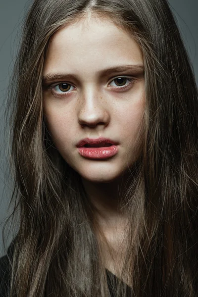 Close-up face portrait of young woman without make-up.