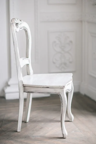 White Wooden Vintage Chair Standing in front of a White Wall on