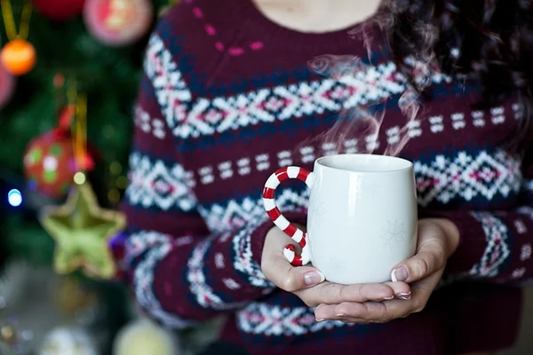 Happy young woman with a christmas cup of cacao