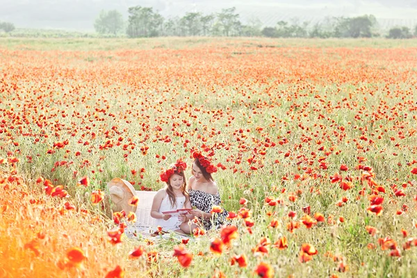 Mother and daughter walking in a poppy field. Summer mood