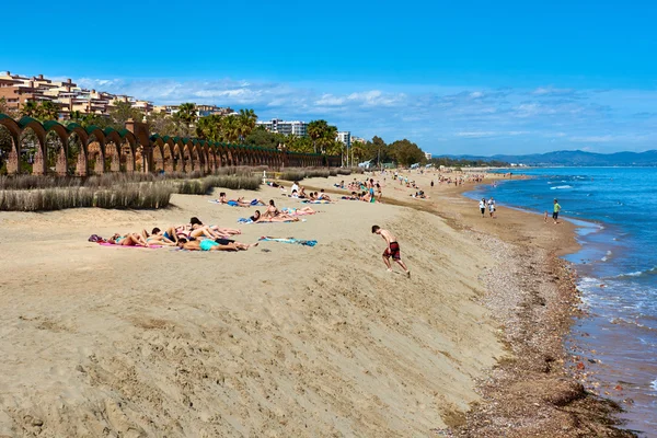 People sunbathing on the Marina dOr beach. Spain