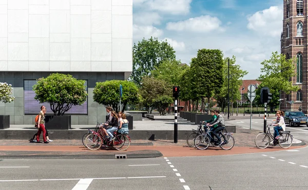 People crossing the street by bicycle