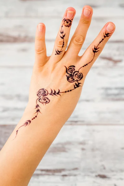 Woman Hand Painted with Floral Figures Using Black Henna