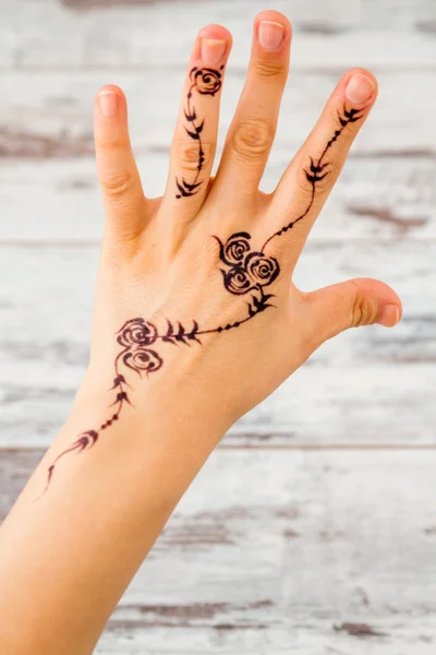 Woman Hand Painted with Floral Figures Using Black Henna