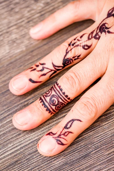 Woman Hand Painted with Floral Figures Using Black Henna