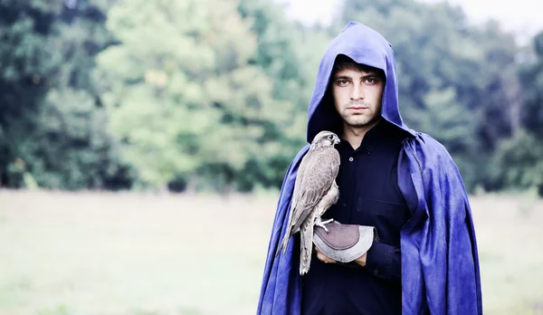 Man in a raincoat with a falcon