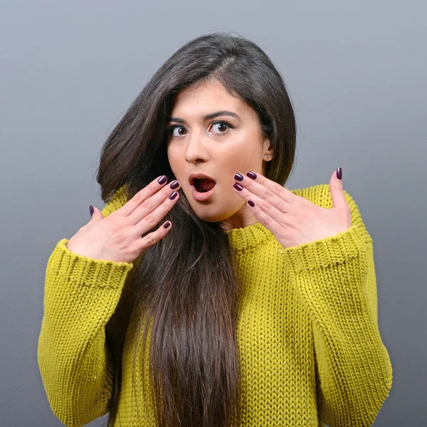 Portrait of scared woman against gray background