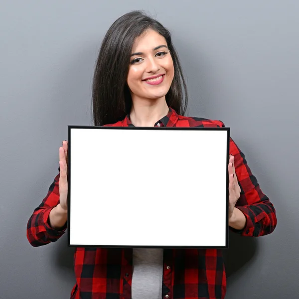 Portrait of smiling woman holding blank sign board.Studio portra