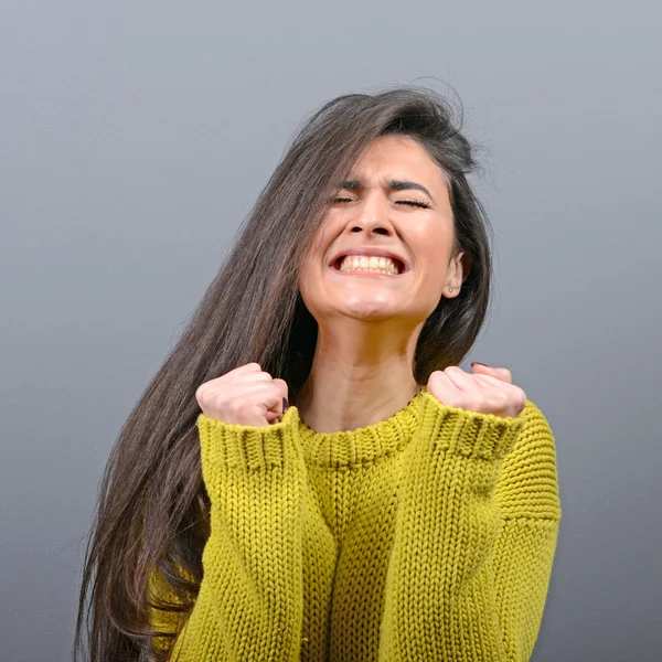 Woman crying and wiping tears against gray background