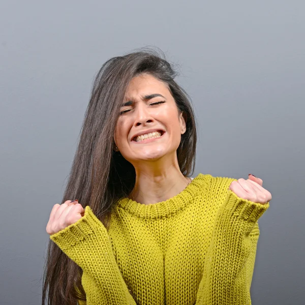 Woman crying and wiping tears against gray background