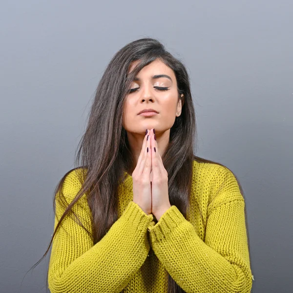 Woman praying about something or begging for mercy against gray