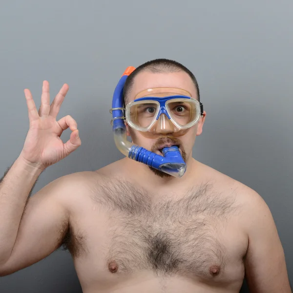 Funny man wearng diving mask against gray background