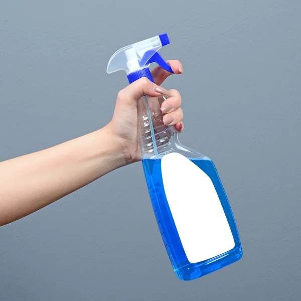 Hand holding cleaning sprayer against gray background - Clean ho