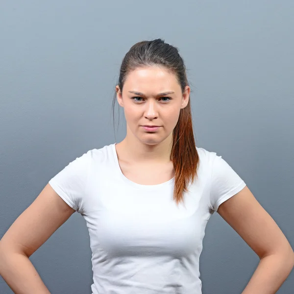 Portrait of mad woman against gray background