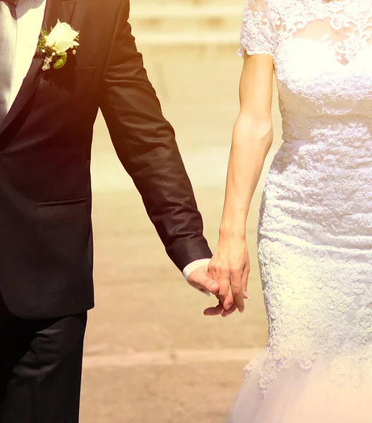 Bride and groom holding hands an walking in new life
