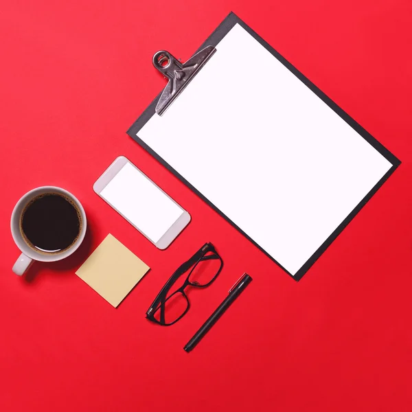 Flat lay of workplace in office with business accessories on red