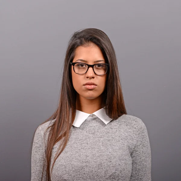 Portrait of a serious business woman against gray background