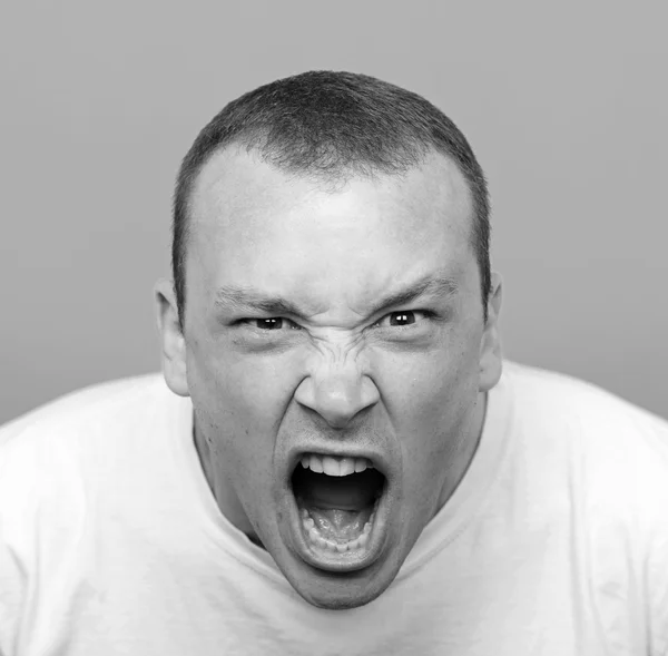 Portrait of angry man screaming against red background